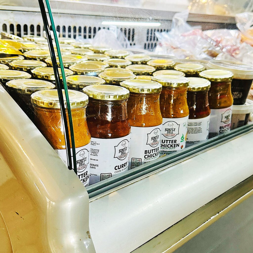 Well-stocked shelves inside MyFish featuring imported olive oils and spices.