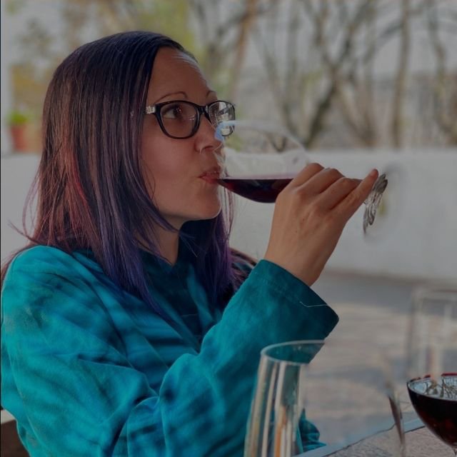 Claudia Sherrintasting red wine from a stemmed glass outdoors at Indaba Hotel Spa and Conference Centre in Johannesburg.