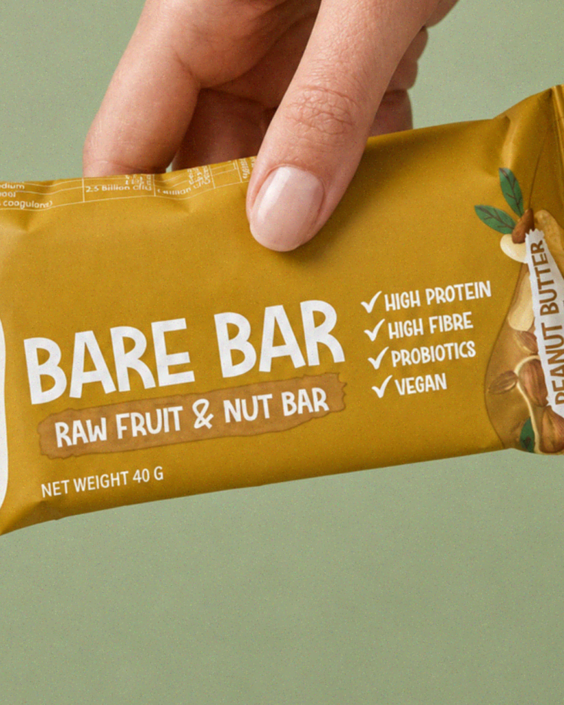 Close-up of a hand holding a Nature's Nutrition Peanut Butter Bare Bar.