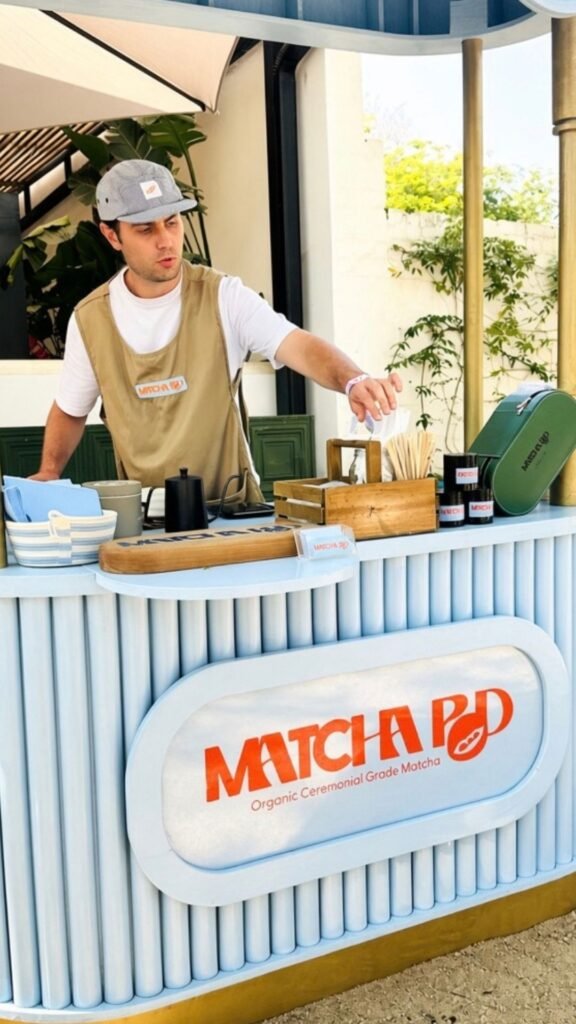A barista preparing organic ceremonial grade matcha at the Matcha Pod station during the Luxurious Marble Circus festival.
