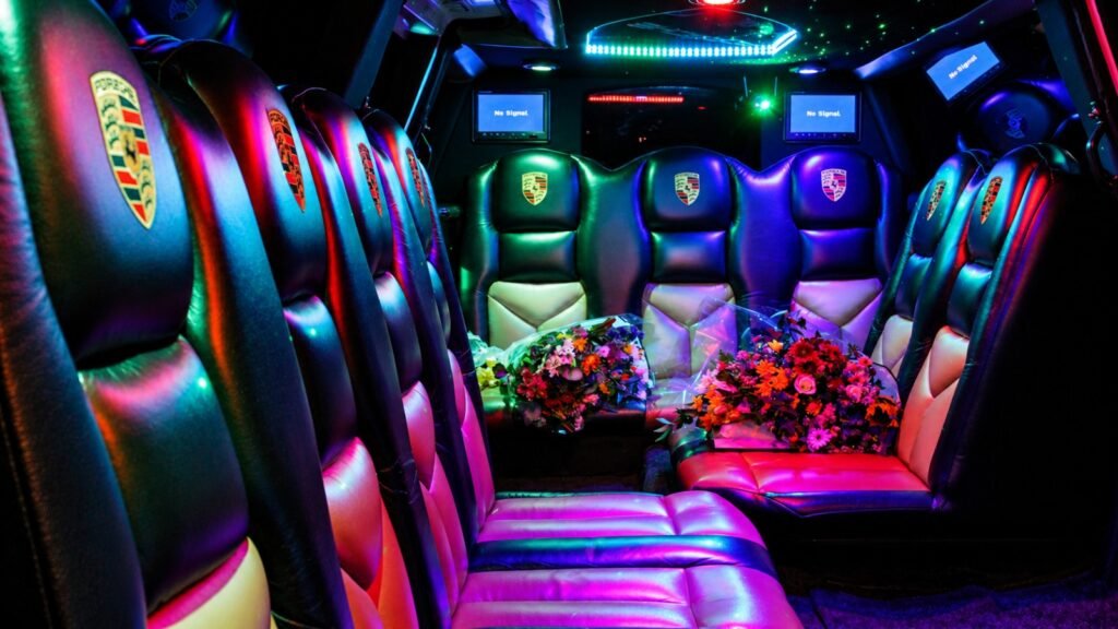 Spacious interior of the white Porsche Cayenne stretch limo with multi-colour LED lighting, Porsche-branded seats and two floral bouquets