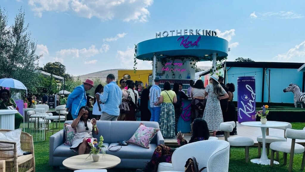 Attendees socializing at the vibrant blue Motherkind activation bar and outdoor lounge seating area during the Luxurious Marble Circus.