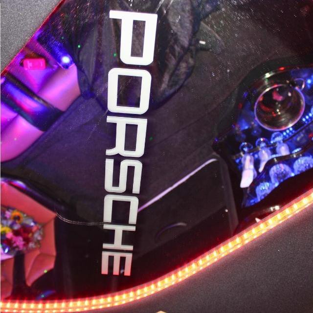 Illuminated vertical PORSCHE lettering on the mirrored ceiling panel inside Luxury Limousines stretch limo