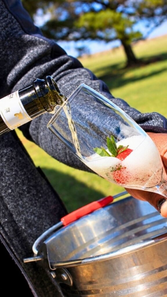 Close-up of champagne being poured into a flute with a fresh strawberry at Sibani Lodge