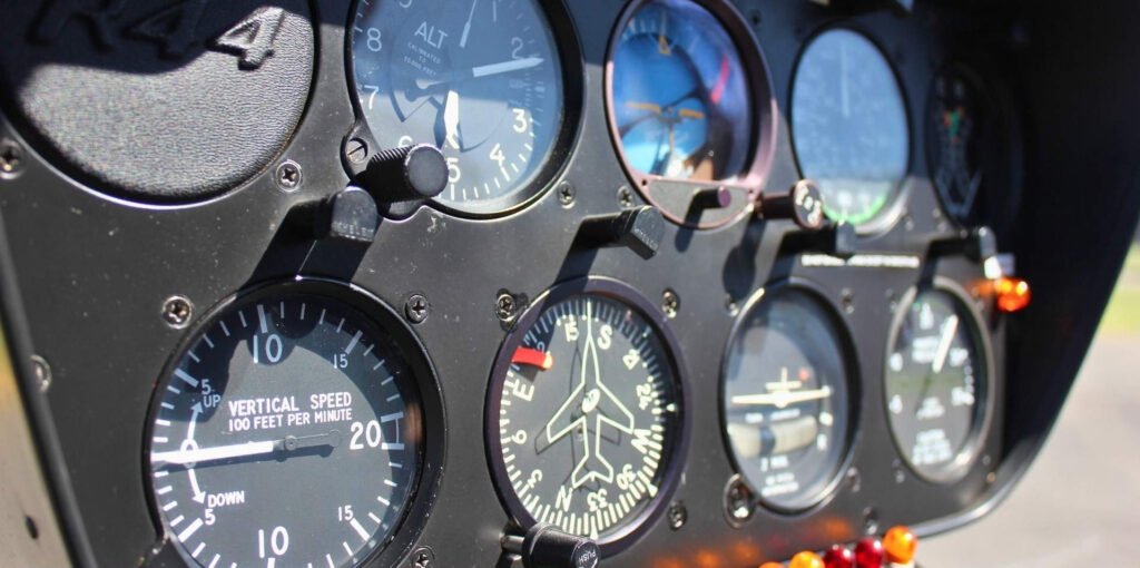 Close-up of the Robinson R44 instrument panel showing altimeter, vertical speed indicator, compass, and flight instruments inside a Helivate helicopter.
