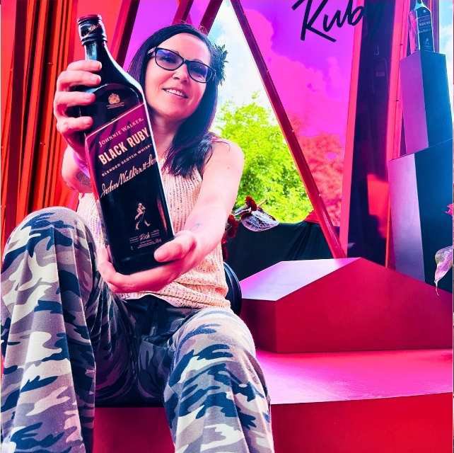 Claudia showcasing a bottle of Johnnie Walker Black Ruby inside the brand activation lounge at the Luxurious Marble Circus.