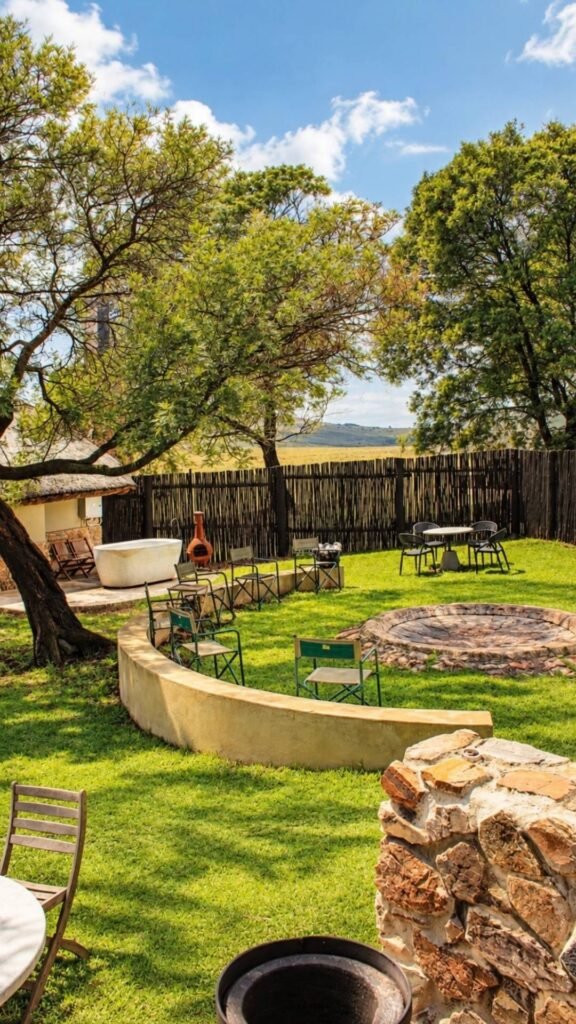 Private courtyard featuring a large stone outdoor bath, fire boma and seating at Sibani Lodge
