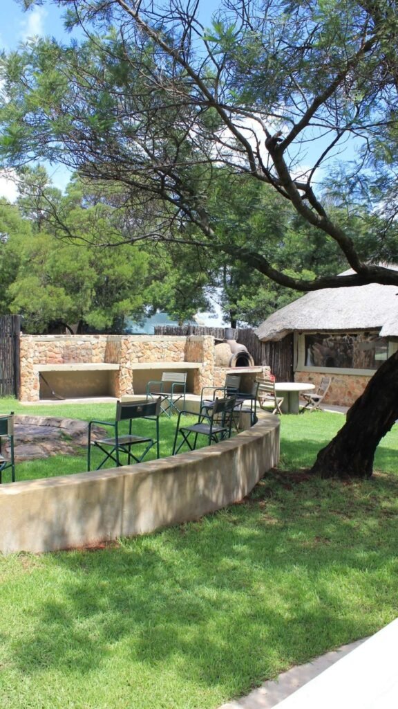 Outdoor braai area with stone pizza oven and seating in the private courtyard of Sibani Lodge