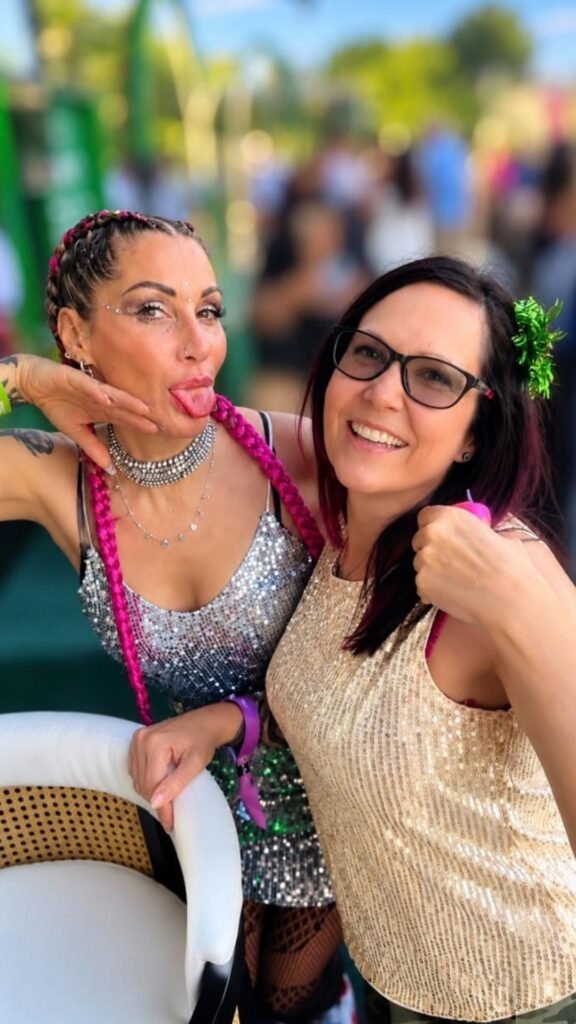 Claudia Sherrin posing with her friend Natalie Palmary in sequined festival attire during the Luxurious Marble Circus event.