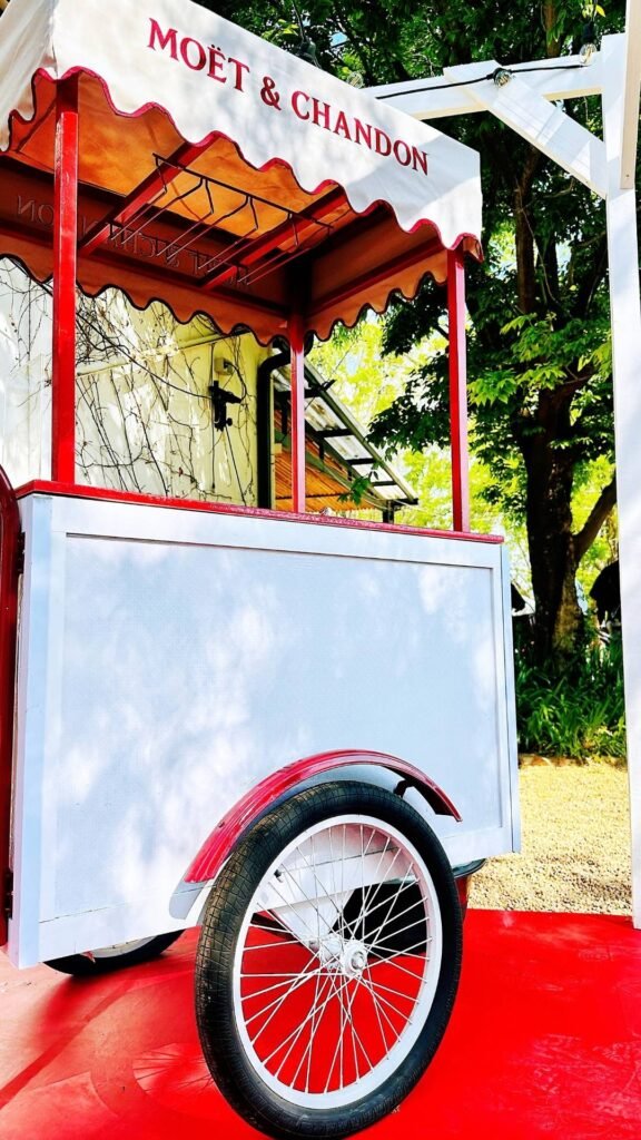 A branded Moët & Chandon mobile bar cart set up outdoors on a red carpet at the Luxurious Marble Circus.