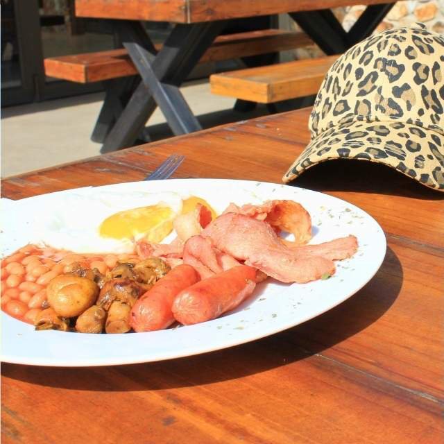 Hearty cooked breakfast with eggs, bacon, sausages and beans at Sibani Lodge